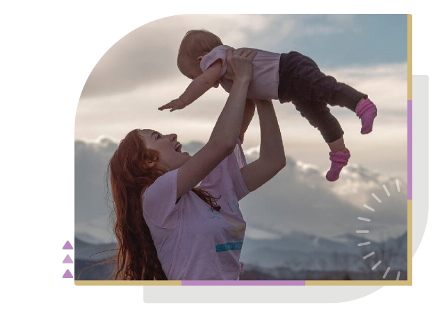 female tossing young child in the air