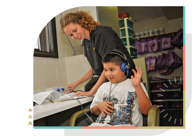 young boy with female nurse taking hearing test