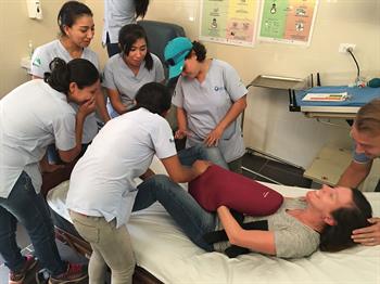 A CU Nursing student simulates going into labor while Guatemalan nurses observe, learn and assist