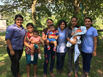 Guatemalan midwives pose for a picture with three mothers and their infants