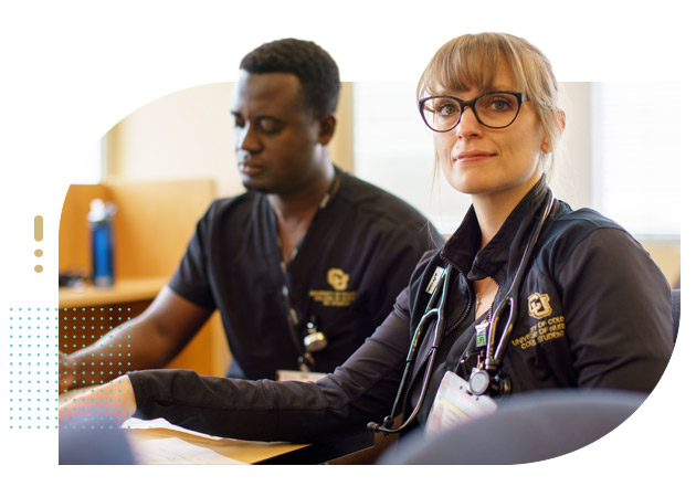 Female and male student nurses in class taking notes