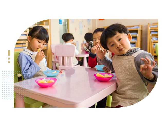 Young children eating snacks in daycare environment