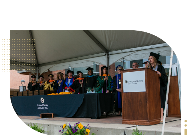 Faculty and college graduate on stage