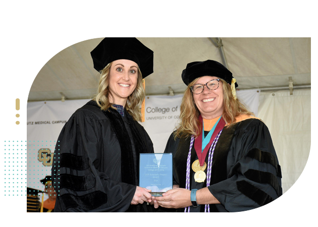 Faculty and college graduate on stage