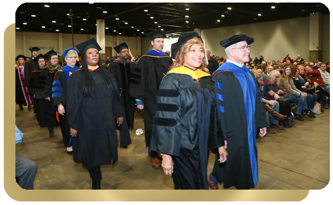 Faculty and student walk in graduation