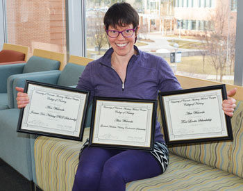 Ann Wislowski holds her three scholarship certificates