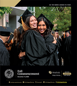 Two women in college cap and gown attire hugging