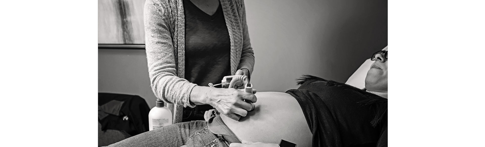 Nurse practioner listening to the sounds of a pregnant woman