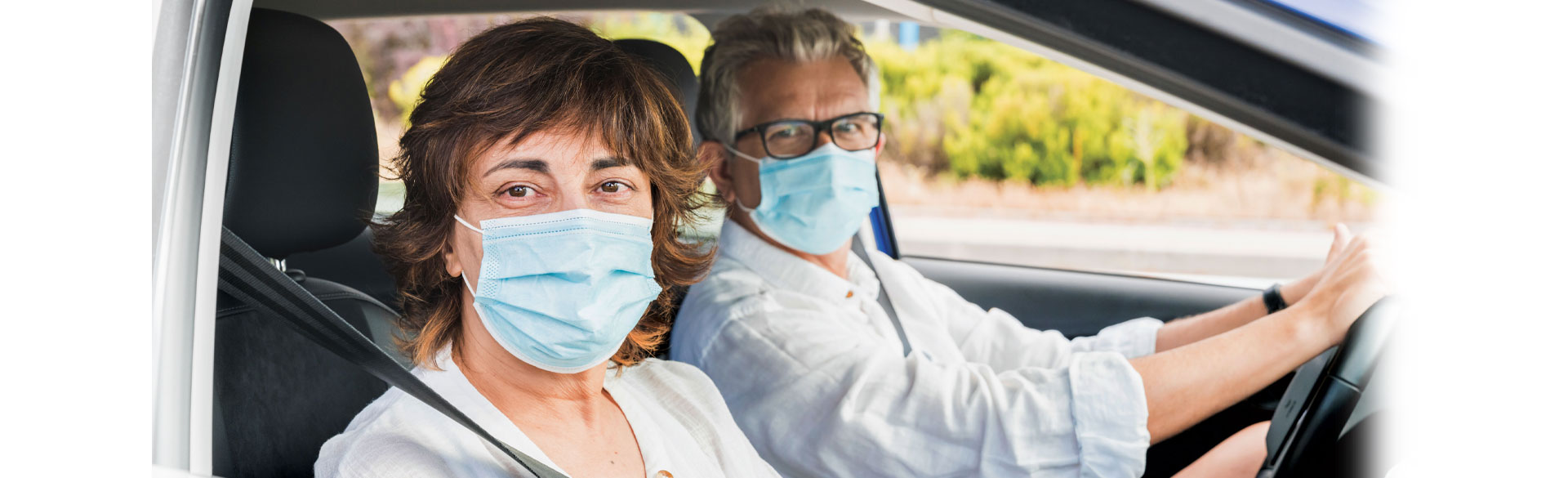 Two people in a car, looking at the camera